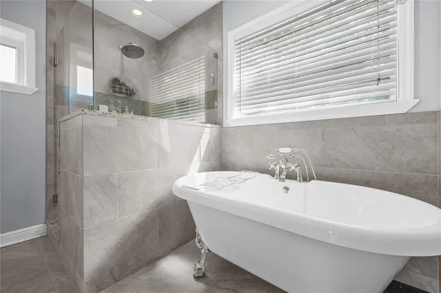 a bathroom with a white bath tub sitting next to a white sink