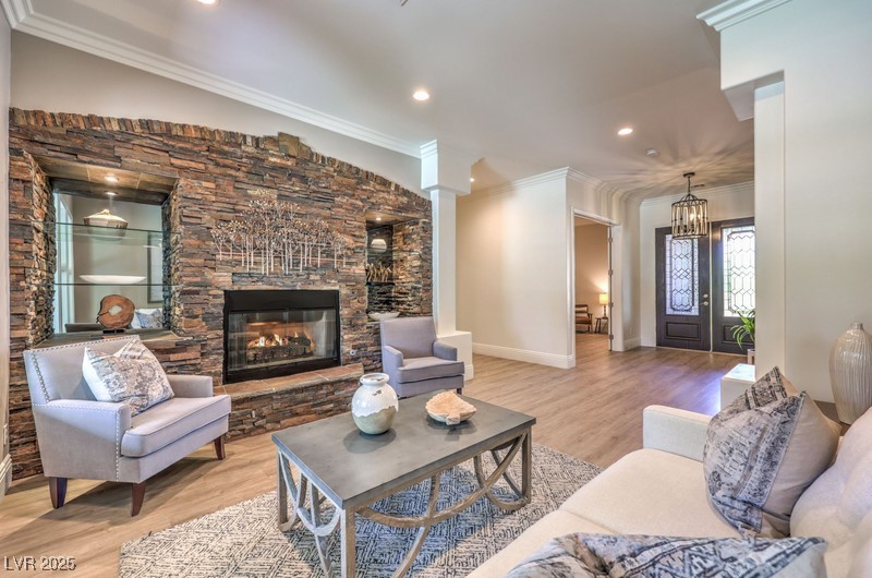 9135 Hickam Avenue Las Vegas, NV 89129 - Photo 12 of 75 Living room with a stone fireplace, light wood-style flooring, ornamental molding, and recessed lighting
