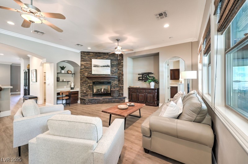9135 Hickam Avenue Las Vegas, NV 89129 - Photo 14 of 75 Living area with ceiling fan, a fireplace, light wood finished floors, arched walkways, and recessed lighting