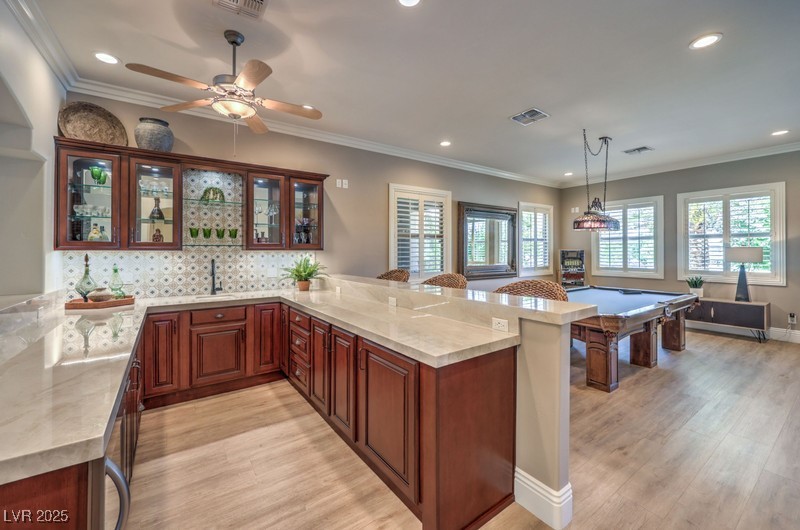 9135 Hickam Avenue Las Vegas, NV 89129 - Photo 20 of 75 Kitchen featuring a peninsula, light wood-style floors, glass insert cabinets, recessed lighting, and backsplash
