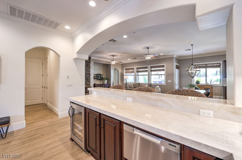 9135 Hickam Avenue Las Vegas, NV 89129 - Photo 22 of 75 Kitchen featuring dishwasher, wine cooler, recessed lighting, arched walkways, and light wood-style flooring