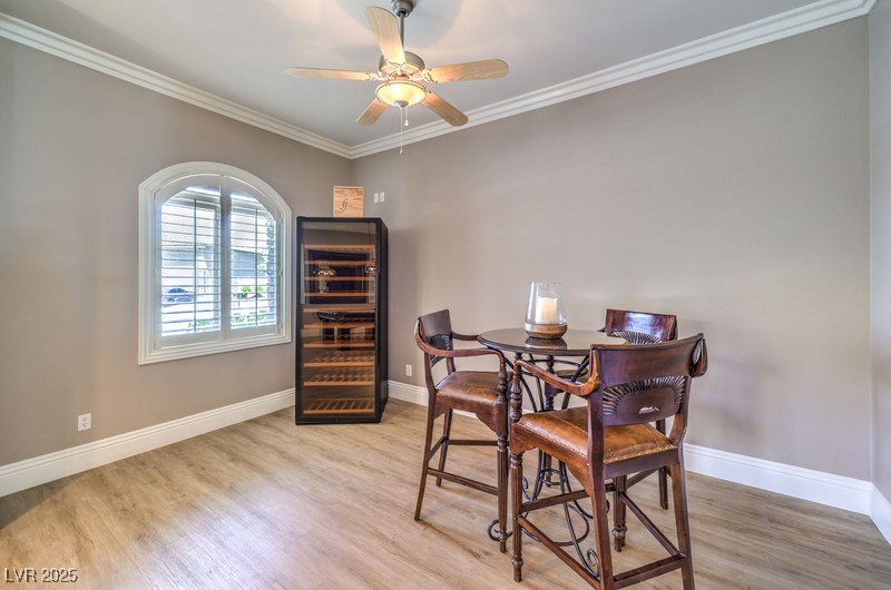 9135 Hickam Avenue Las Vegas, NV 89129 - Photo 25 of 75 Dining room with beverage cooler, light wood-style floors, crown molding, and a ceiling fan