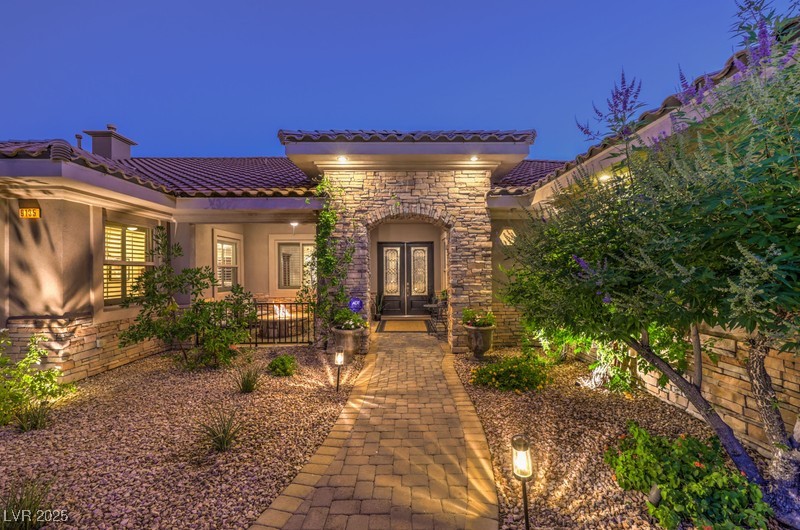 9135 Hickam Avenue Las Vegas, NV 89129 - Photo 3 of 75 Entrance to property with french doors, a tiled roof, stucco siding, stone siding, and a chimney