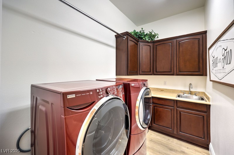 9135 Hickam Avenue Las Vegas, NV 89129 - Photo 39 of 75 Laundry room with washer and dryer, cabinet space, light wood-type flooring, and bar with sink