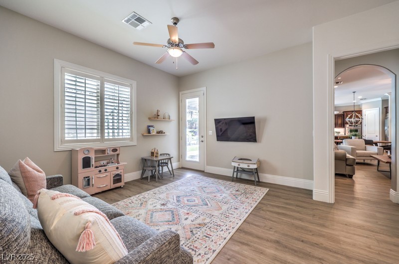 9135 Hickam Avenue Las Vegas, NV 89129 - Photo 40 of 75 Living area featuring a ceiling fan, healthy amount of natural light, wood finished floors, and arched walkways