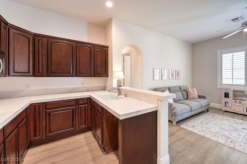 9135 Hickam Avenue Las Vegas, NV 89129 - Photo 75 of 75 Kitchen featuring a peninsula, open floor plan, light wood finished floors, arched walkways, and recessed lighting