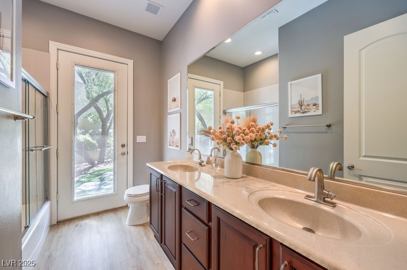 9135 Hickam Avenue Las Vegas, NV 89129 - Photo 45 of 75 Full bath featuring wood finished floors, plenty of natural light, double vanity, and combined bath / shower with glass door