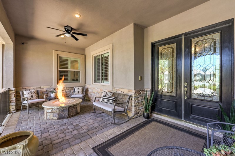 9135 Hickam Avenue Las Vegas, NV 89129 - Photo 7 of 75 Doorway to property with stucco siding, french doors, stone siding, and ceiling fan