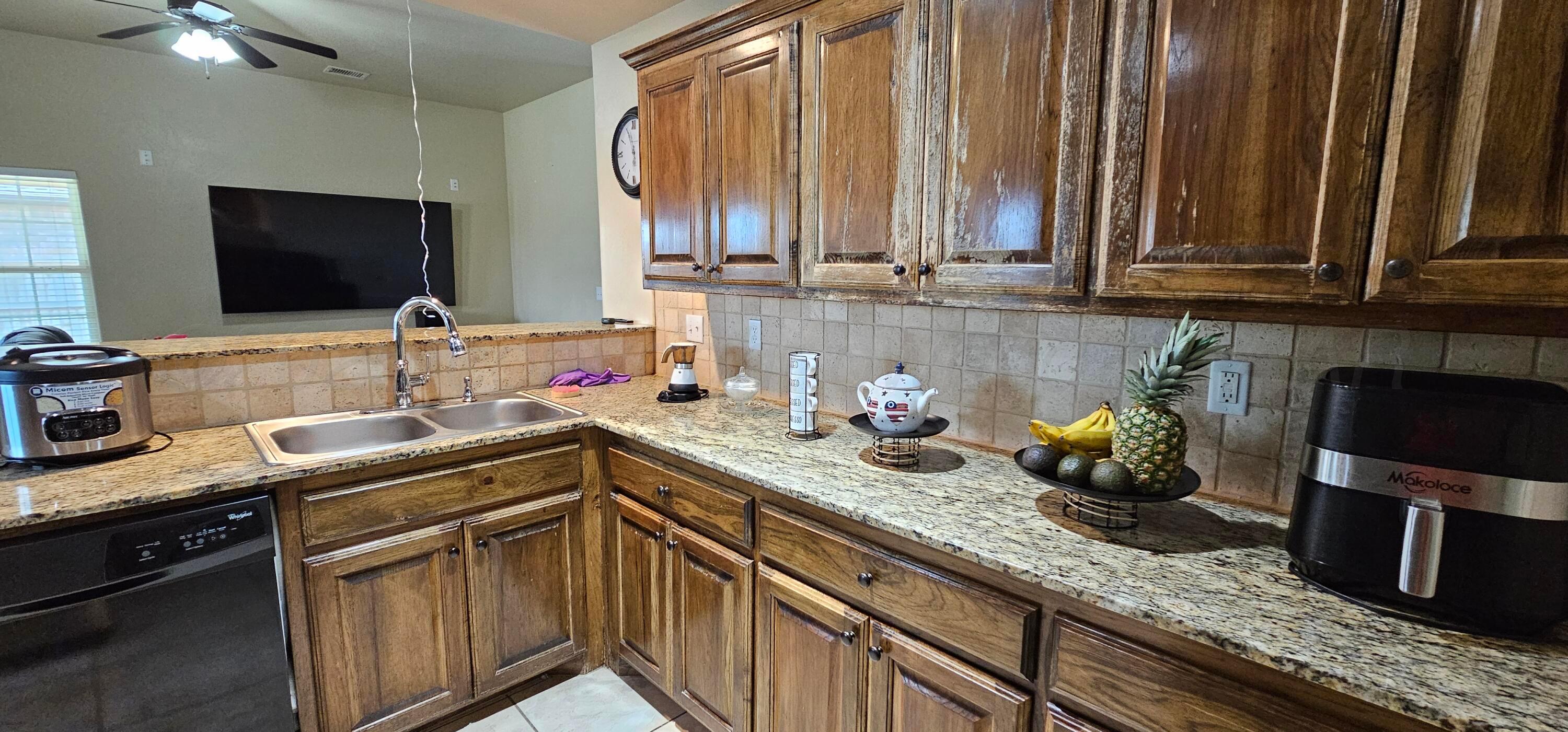 1819 Wagon Trail Road Dalhart, TX 79022 - Photo 3 of 15 a kitchen with stainless steel appliances granite countertop a sink stove and cabinets