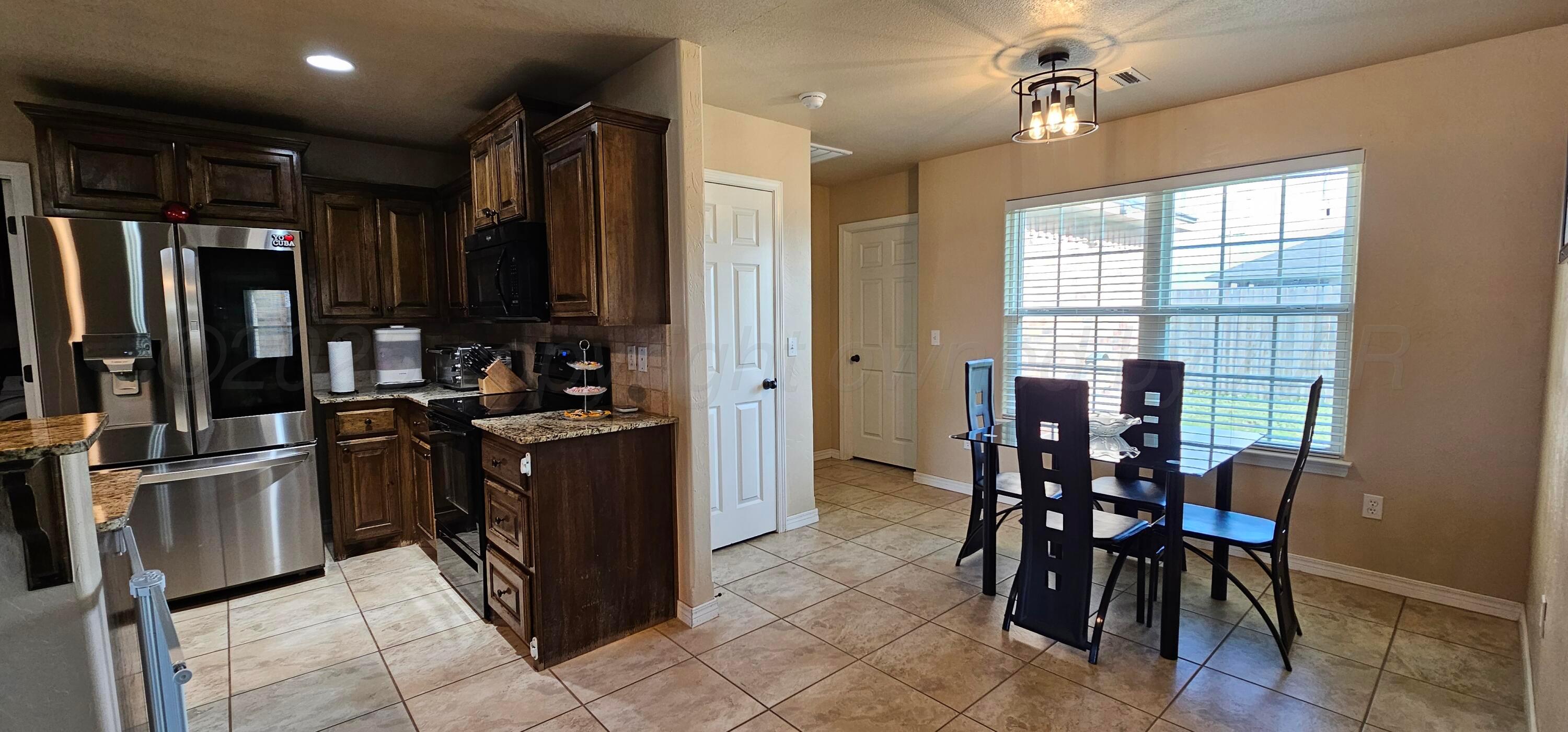 1819 Wagon Trail Road Dalhart, TX 79022 - Photo 4 of 15 a kitchen with stainless steel appliances kitchen island granite countertop a refrigerator and a stove top oven