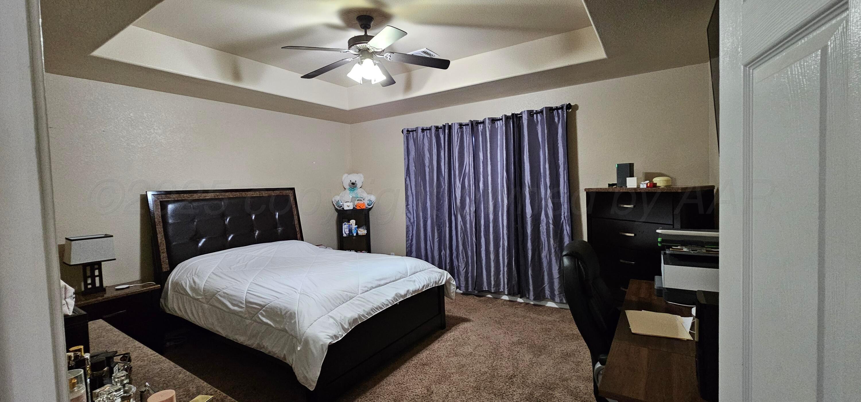 1819 Wagon Trail Road Dalhart, TX 79022 - Photo 7 of 15 a bedroom with a bed and a chandelier
