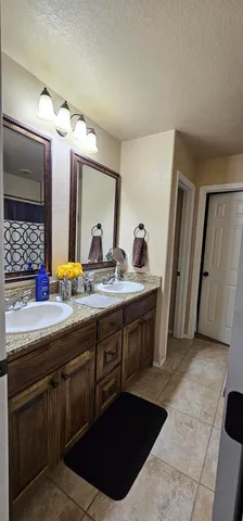 a spacious bathroom with a double vanity sink and a mirror
