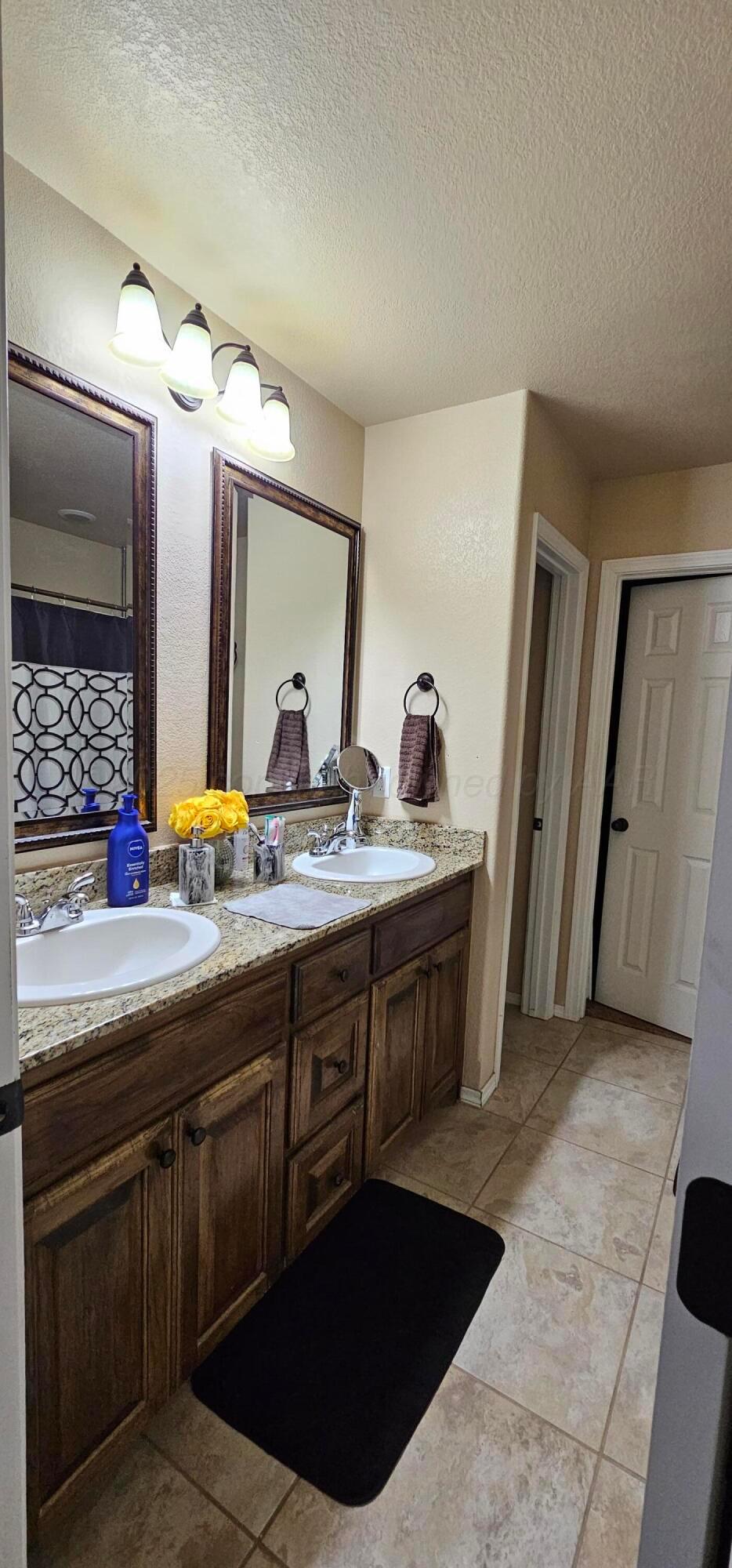 1819 Wagon Trail Road Dalhart, TX 79022 - Photo 8 of 15 a spacious bathroom with a double vanity sink and a mirror