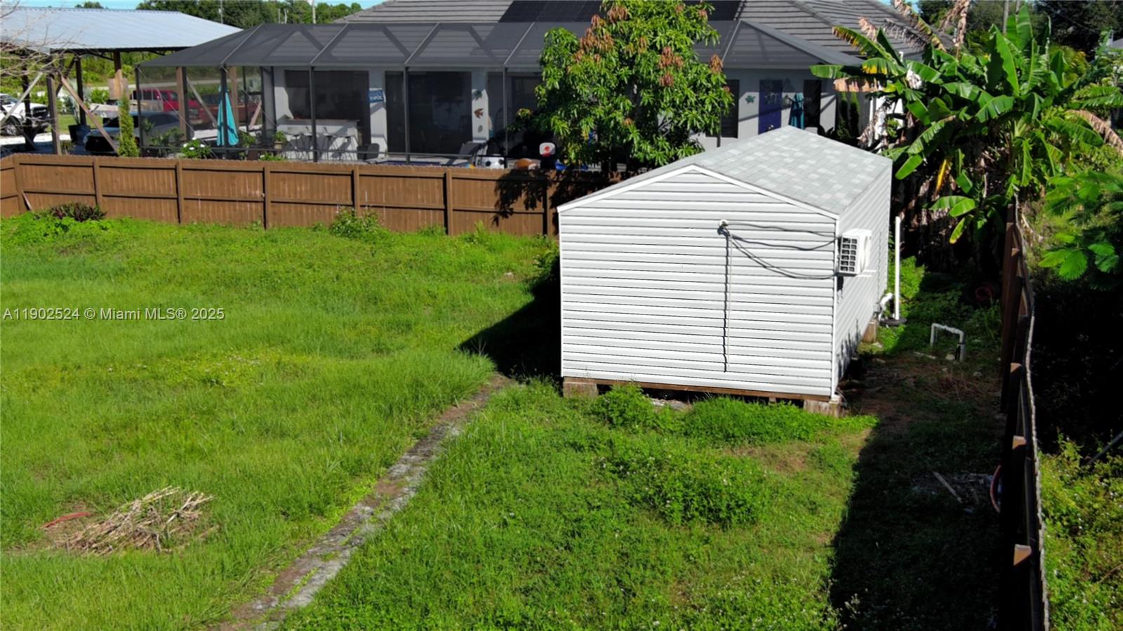 3216 22nd Street Southwest Lehigh Acres, FL 33976 - Photo 26 of 28 a view of a white house with a yard and sitting area