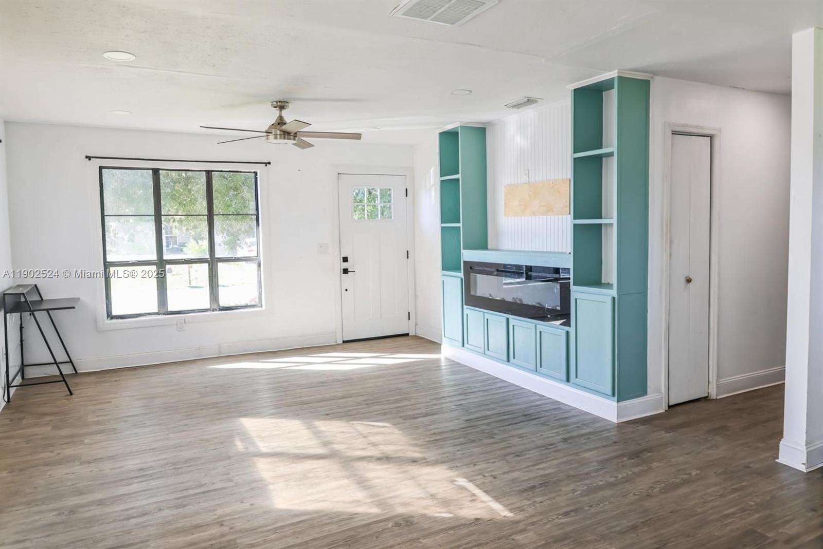 3216 22nd Street Southwest Lehigh Acres, FL 33976 - Photo 4 of 28 an empty room with wooden floor fan and windows