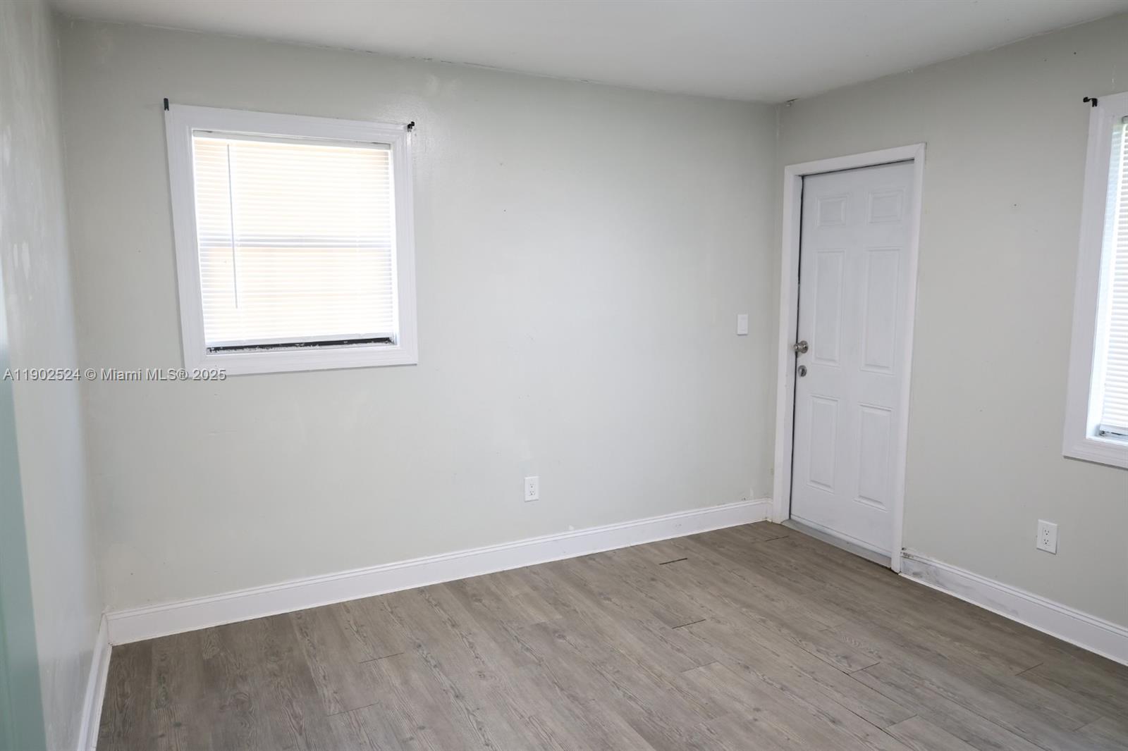 3216 22nd Street Southwest Lehigh Acres, FL 33976 - Photo 7 of 28 an empty room with wooden floor and a window