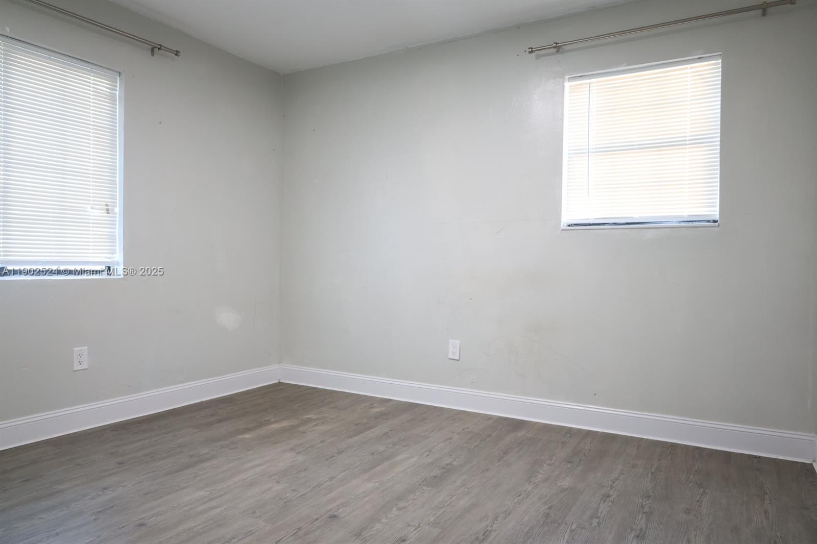 3216 22nd Street Southwest Lehigh Acres, FL 33976 - Photo 10 of 28 an empty room with wooden floor and windows