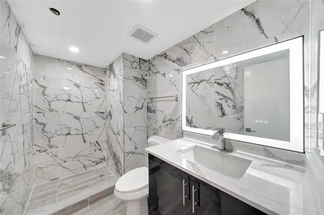 a bathroom with a sink toilet a mirror and shower