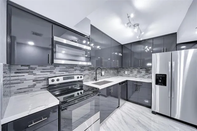 a kitchen with stainless steel appliances a sink stove and refrigerator