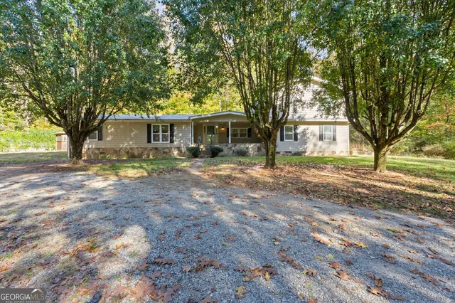 a front view of a house with a yard and trees