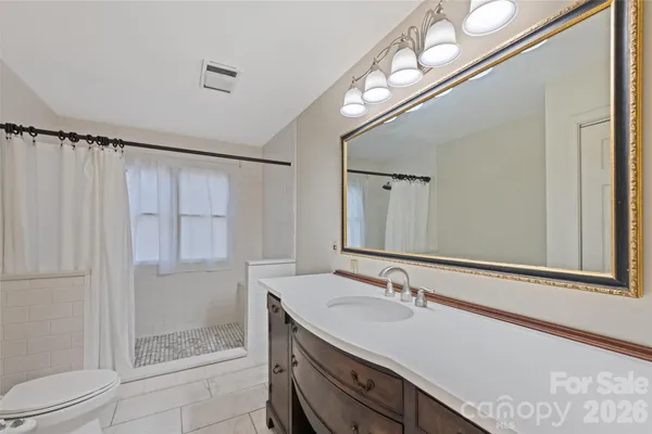 a bathroom with a granite countertop sink a toilet and a mirror