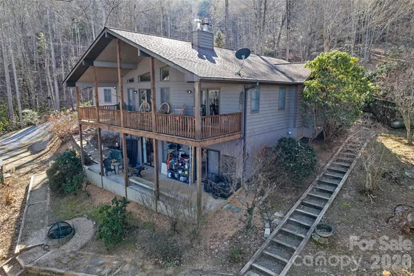 a view of a house with a yard and lawn chairs