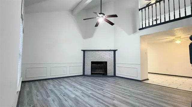 a view of a livingroom with wooden floor a fireplace and entryway