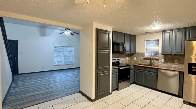 a kitchen with stainless steel appliances granite countertop a sink and a refrigerator