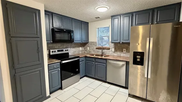 a kitchen with stainless steel appliances granite countertop a refrigerator stove and microwave