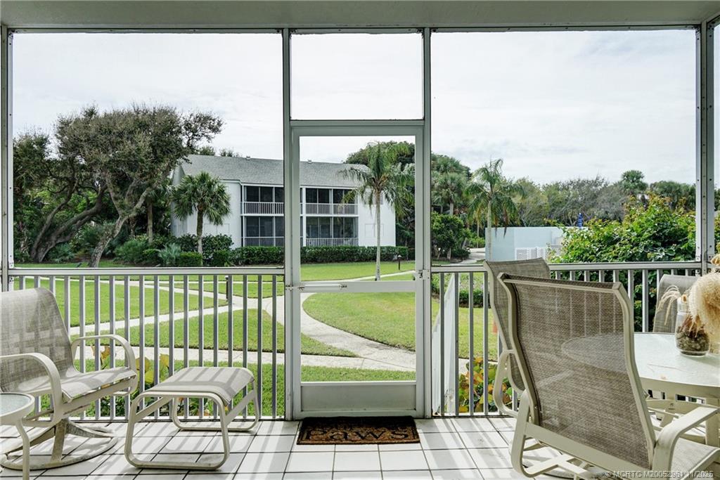 1550 Northeast Ocean Boulevard, Unit B101 Stuart, FL 34996 - Photo 19 of 32 a view of a balcony with floor to ceiling window next to a yard