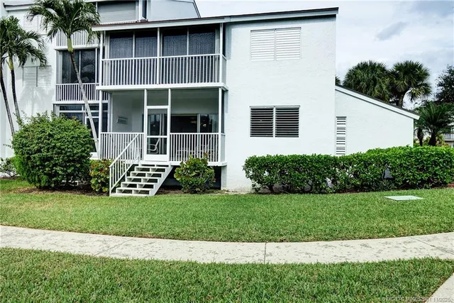 a view of a house with a yard and palm trees