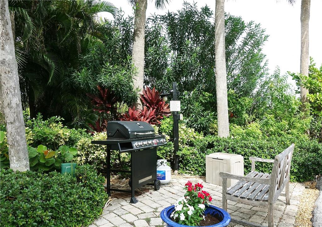 1550 Northeast Ocean Boulevard, Unit B101 Stuart, FL 34996 - Photo 26 of 32 a backyard of a house with lots of green space and fountain
