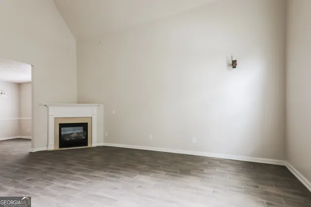 a view of empty room with wooden floor and fireplace