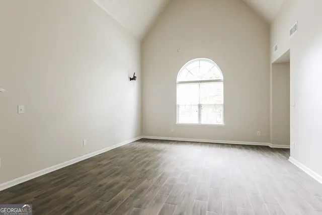 an empty room with wooden floor and a window