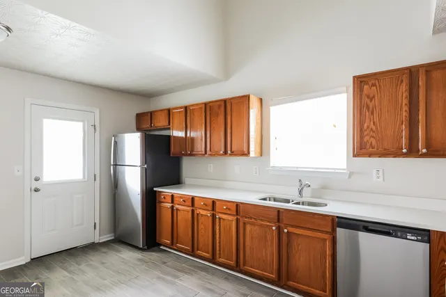 a kitchen with stainless steel appliances granite countertop a refrigerator and a sink