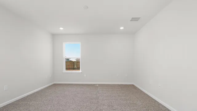 an empty room with a window and a bathroom