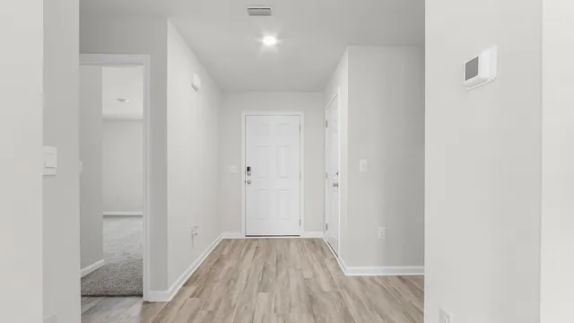a view of a hallway with wooden floor