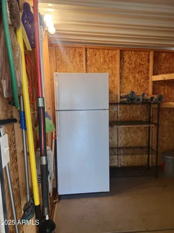 a view of kitchen with furniture and refrigerator