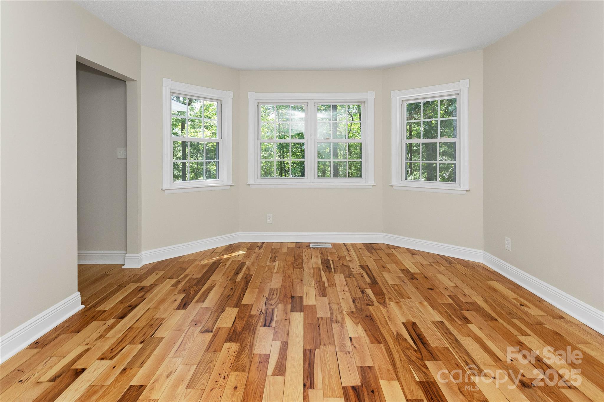 233 Youngs Cove Road Candler, NC 28715 - Photo 11 of 47 a view of empty room with wooden floor and fan