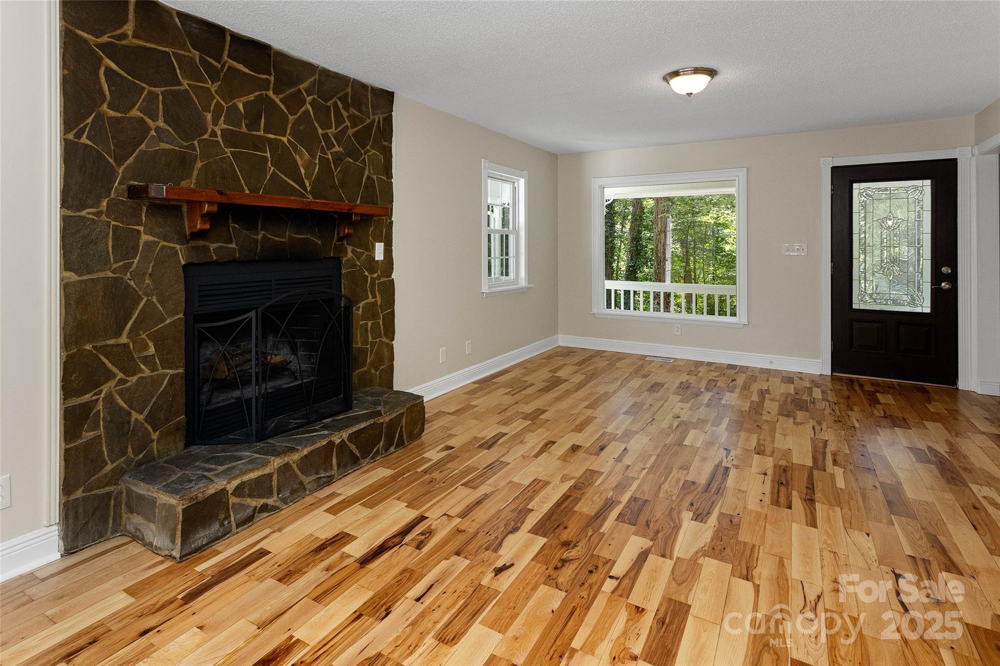 233 Youngs Cove Road Candler, NC 28715 - Photo 3 of 47 a living room with a fireplace wooden floor and a window