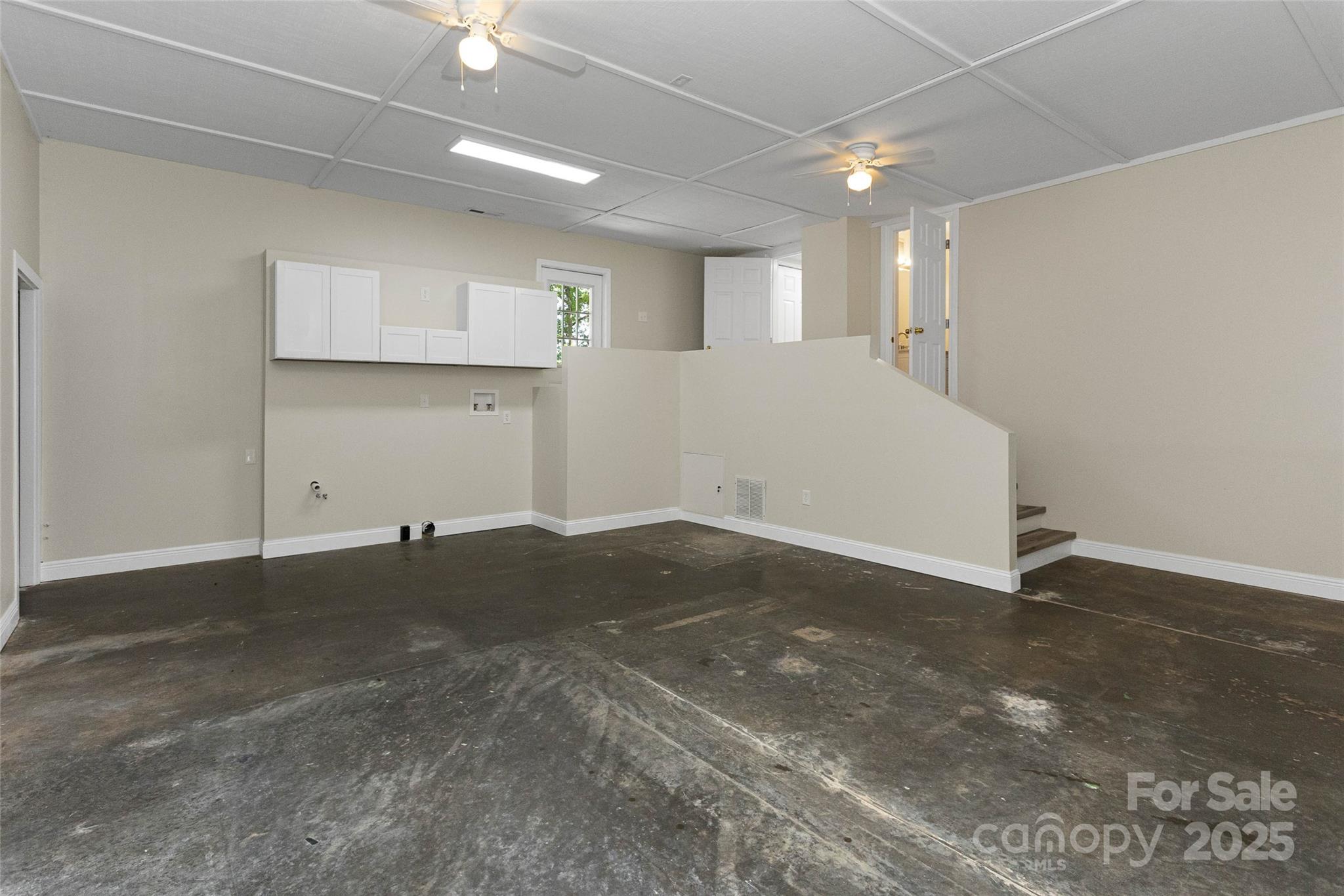 233 Youngs Cove Road Candler, NC 28715 - Photo 36 of 47 a view of a big room with wooden floor and a ceiling fan
