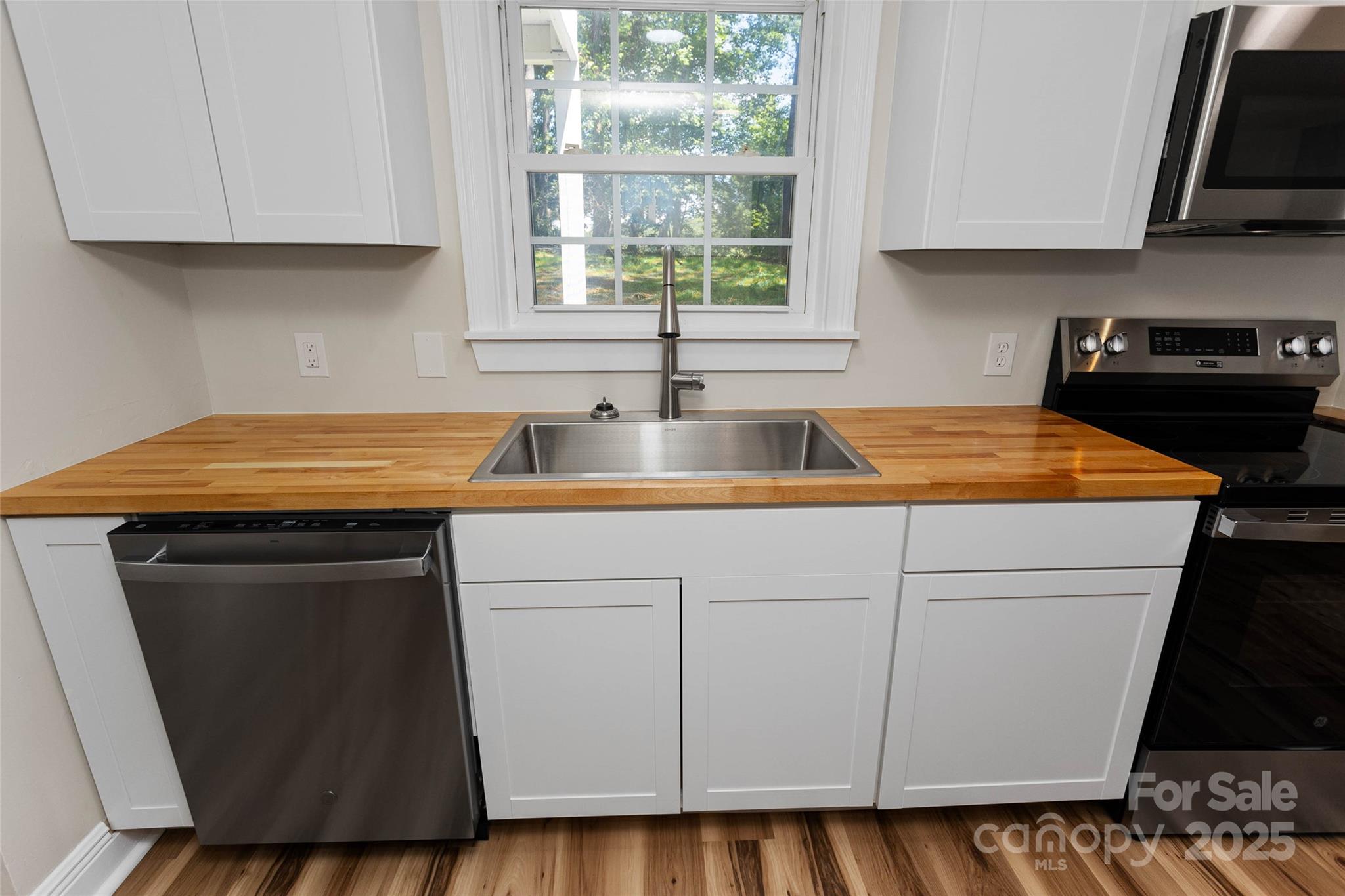 233 Youngs Cove Road Candler, NC 28715 - Photo 9 of 47 a kitchen with granite countertop white cabinets and a sink