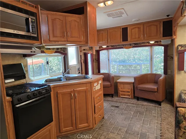 a kitchen with stainless steel appliances granite countertop a refrigerator and a stove top oven