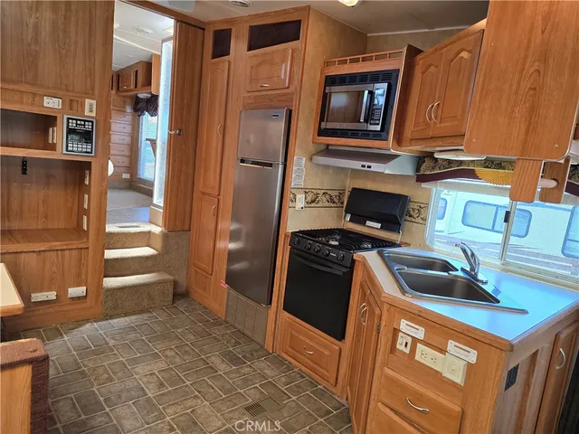 a kitchen with stainless steel appliances granite countertop a refrigerator and a stove