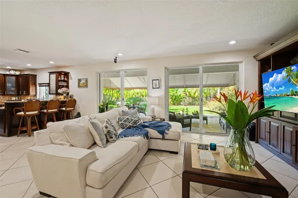 a living room with furniture flat screen tv and a large window