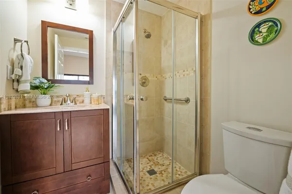 a bathroom with a granite countertop sink toilet and shower