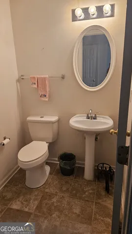 a bathroom with a toilet a sink and a mirror