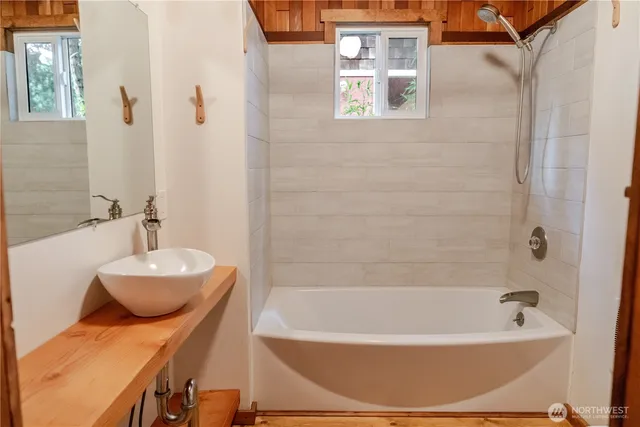 a bathroom with a sink a bathtub and a mirror