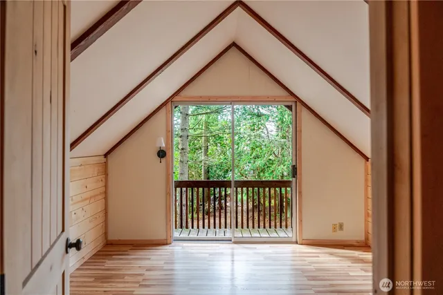 a view of empty room with wooden floor and windows