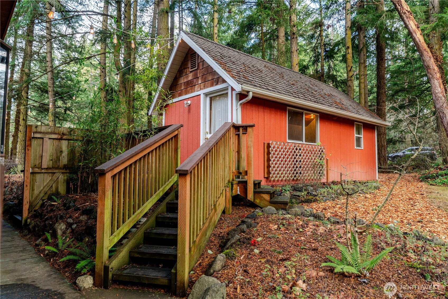 4533 South Discovery Road Port Townsend, WA 98368 - Photo 22 of 32 a front view of a house with wooden fence and trees